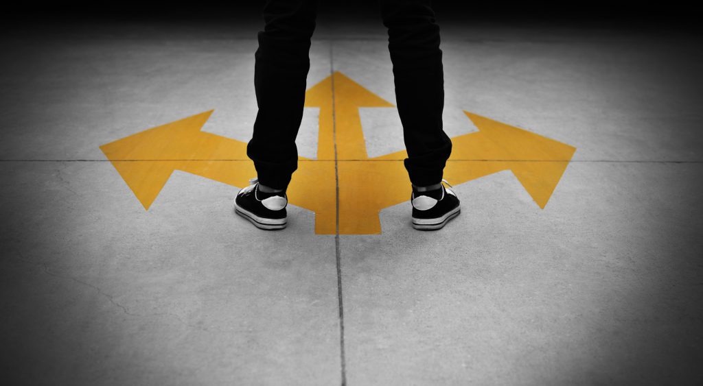 Young man feet and three yellow arrows painted on floor When choosing ERP(Enterprise Resource Planning) System in Singapore