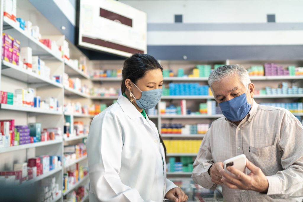 Female pharmacist helping a senior customer, How ERP System benefits Pharmaceutical Distributors?